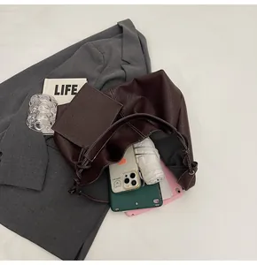Detail view of large brown soft leather tote bag showing spacious capacity with daily items