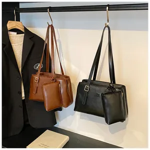 Detail view of adjustable strap buckles and matching mini pouches on tote bags