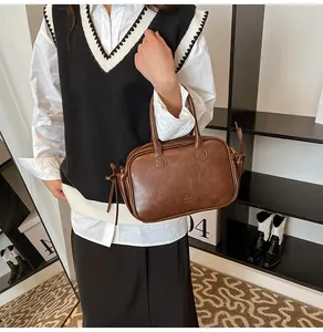 Close-up of a dark brown leather handbag with side bow detail and matte finish texture