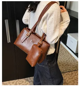 Detail of vintage brown tote bag with adjustable strap and matching small zipper pouch