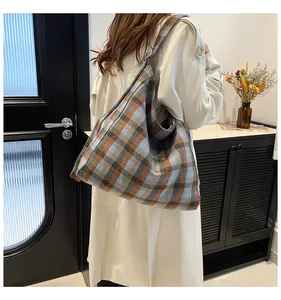 Detail of checkered plaid tote bag showing texture and capacity on a model shoulder