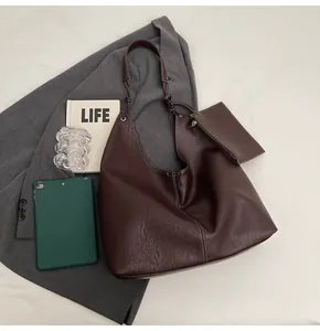 Macro detail of brown leather tote texture with white stitching and matching coin purse
