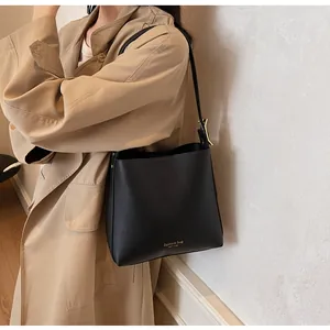 Detail showing the embossed Fashion Bag New York text on black leather bucket bag