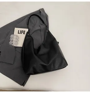 Detailed view of black hobo tote bag with soft faux leather texture and minimalist stitching