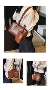 Detail of brown tote bag with gold buckle strap and matching mini pouch accessory