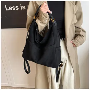 Dettaglio borsa shopper nera grande con tasche laterali e anelli in metallo dorato