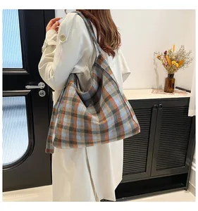 Detail view of large checkered tote bag with orange and blue pattern on model