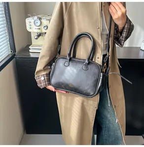 Close-up of black vintage leather handbag with gold lettering in a lifestyle setting