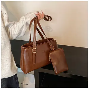 Detail of red-brown retro leather tote with matching coin purse and stylish logo text
