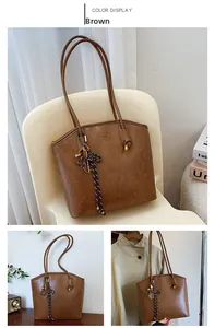 Detail view of brown vintage tote bag featuring faux leather texture and brand embossing