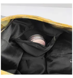 Detail view of plaid tote bag interior showing the zippered pocket and black lining