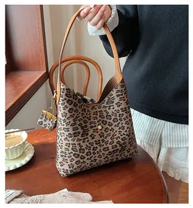Detail view of leopard print tote bag with mini pouch and gold hardware clasp in setting
