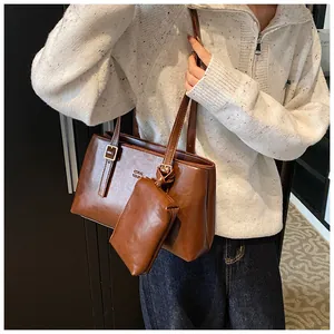Detail of vintage brown tote bag with metal buckle and hanging zipper pouch accessory