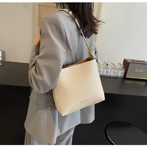 Detail view of the beige bucket bag with adjustable strap and fashion bag logo