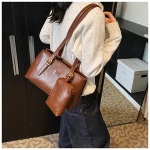 Detailed back view of vintage dark brown faux leather tote bag with small hanging pouch