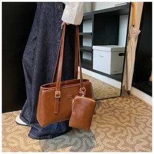 Detail view of dark brown faux leather tote with matching mini pouch and gold hardware