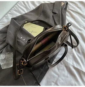 Top view of open dark brown leather bag showing interior storage and gold hardware
