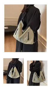 Detail of a large hobo bag in textured bean green and beige fabric with black straps