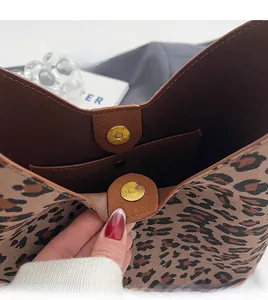 Detail view of leopard print tote bag featuring gold magnetic closure and inner pocket