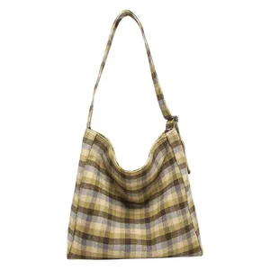 Vintage plaid tote bag with crescent shape and top zipper for winter fashion styling