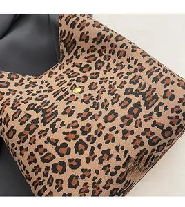 Close-up of leopard print fabric bag with high-quality golden metal snap closure button
