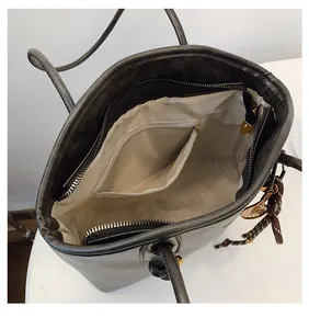 Macro shot of dark grey tote bag interior with zipper pocket and metal slider details