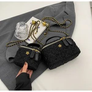 Detailed comparison of two black tweed mini bags with woven chain straps and floral accents