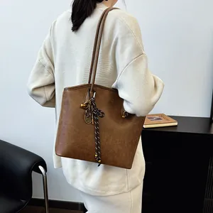 Retro brown oversized tote bag with vintage texture and tennis racket charm detail