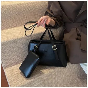 Detail of black faux leather tote bag set with golden hardware on a beige carpet staircase