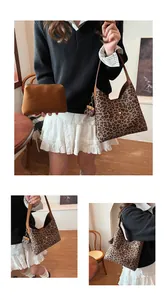 Detailed view of leopard print tote bag with brown shoulder strap and matching clutch set