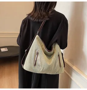 Detail view of green textured tote bag featuring double vertical front zipper pockets