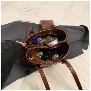 Top view of spacious interior compartments in a dark brown tote bag holding cosmetics