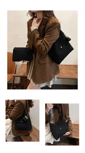 Detail of minimalist black hobo tote bag and zipper pouch set with golden hardware