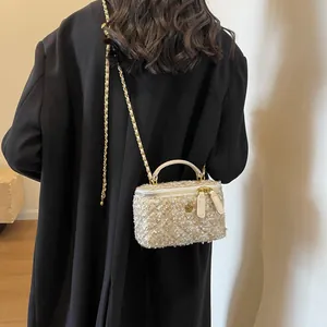 Elegant tweed crossbody bag with gold metallic threads and a decorative floral accent