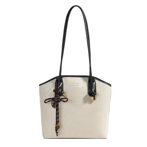 Retro cream tote bag with black handles and woven pendant for daily commute style
