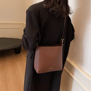 Brown leather bucket shoulder bag with adjustable strap and fashion lettering for women