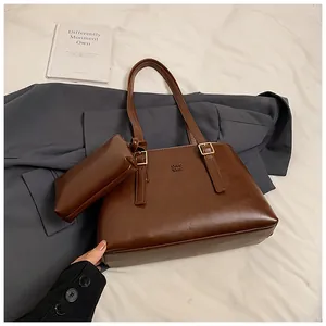 Detailed close-up of dark brown tote bag with small matching pouch and letter embossing
