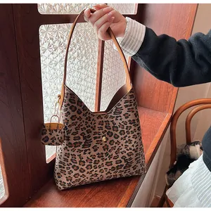Detail of leopard print tote bag with brown leather handle and matching mini pouch