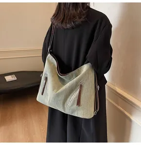 Close-up of Sage Green Denim Hobo Bag with leather straps shown on model's shoulder