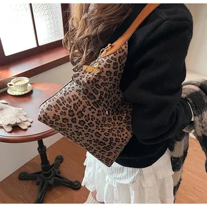 Leopard print hobo bag with matching mini pouch shown in a cozy indoor lifestyle setting