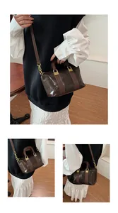 Detailed view of deep brown oily wax leather texture and golden hardware on crossbody bag