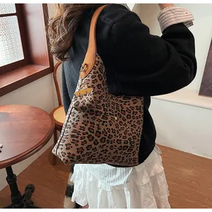 Close-up of leopard print tote bag featuring a leather strap and matching mini pouch accessory