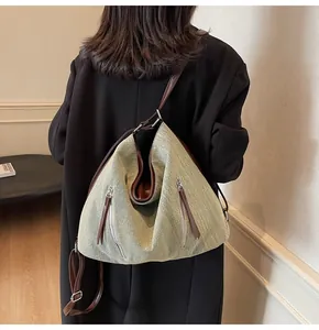 Detailed view of the large capacity crossbody bag with vertical zippers and leather straps