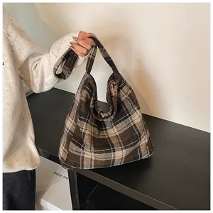 Detail van de zachte retro ruitjes shopper van dikke wol met comfortabel handvat