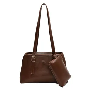 Dark brown tote bag set with matching pouch and adjustable gold buckles on white background