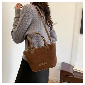 Detailed macro view of retro brown suede handbag texture with adjustable shoulder strap