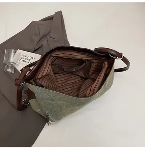 Interior detail of large canvas tote bag with striped lining and leather trim