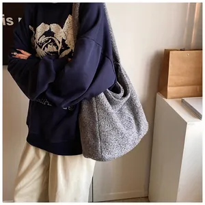 Detail van grijze wollen shopper met zachte textuur en een brede comfortabele riem