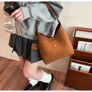 Close-up of brown suede hobo bag with magnetic closure and matching mini pouch accessory