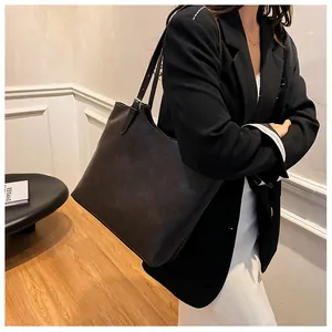 Vista laterale di una modella che indossa una borsa tote vintage in pelle PU nera
